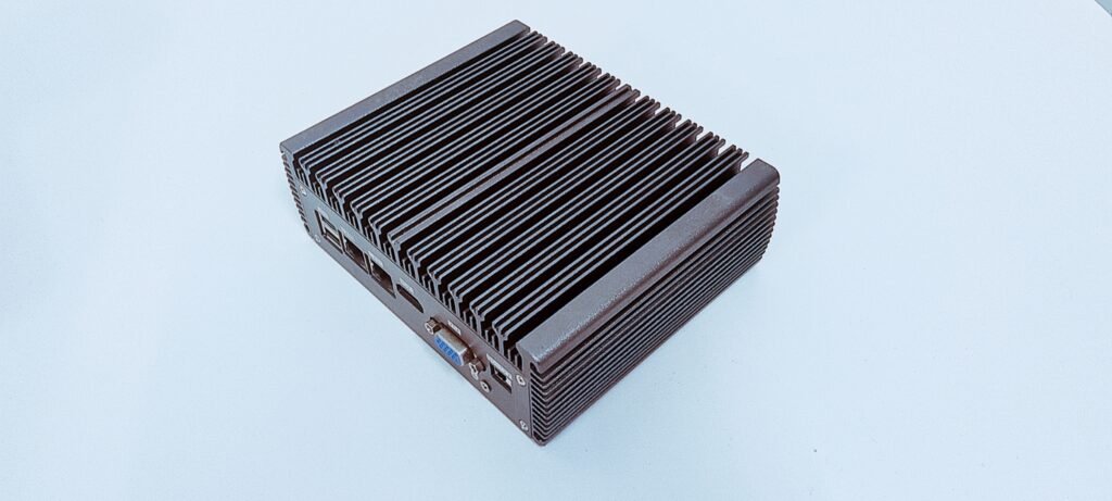 Front panel of a fanless industrial PC showing COM ports, USB, audio, and antenna connectors