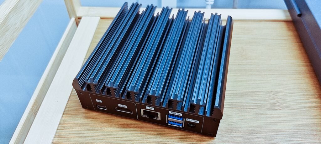 Rear I/O panel of the fanless industrial mini PC showing USB-C DP, HDMI, RJ45 LAN, USB 3.0 ports, and DC power input